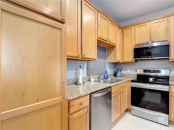 a kitchen with stainless steel appliances granite countertop cabinets and a refrigerator