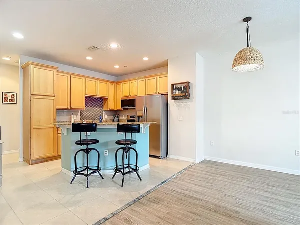 a kitchen with granite countertop a refrigerator stove top oven and sink