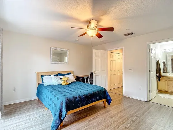 a bedroom with a bed and wooden floor