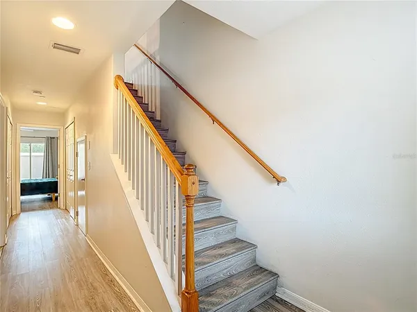 a view of staircase with lots of frames on wall and wooden floor