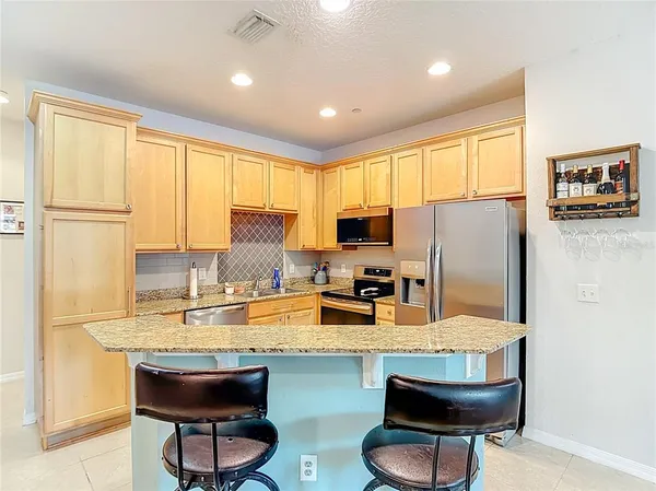 a kitchen with granite countertop counter space appliances a sink and a refrigerator
