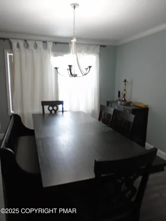 a view of a dining room with furniture and a chandelier