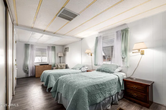 a bedroom with a bed and wooden floor