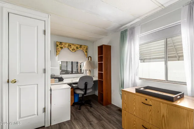a view of a livingroom with workspace and a window
