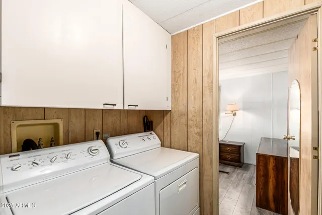 a view of washer and dryer with bathroom in the background