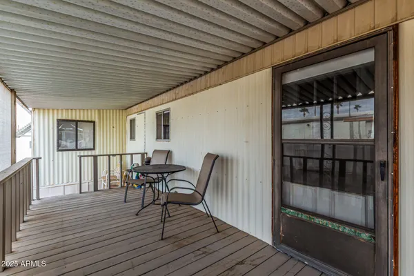 a view of a patio with table and chairs with wooden floor and fence