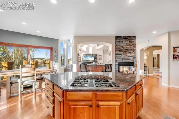 a kitchen with stainless steel appliances granite countertop a stove and a view of living room