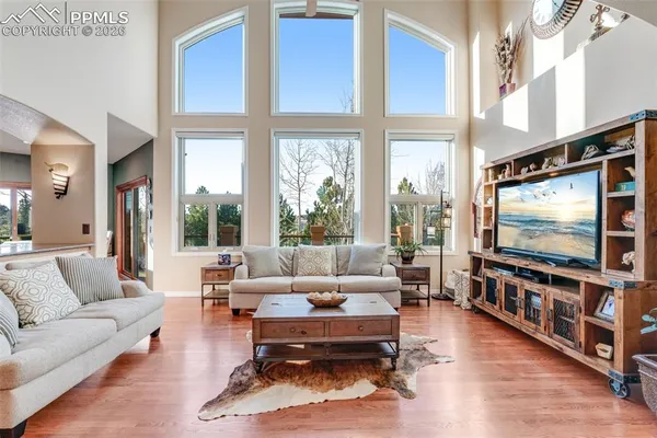 a living room with furniture a flat screen tv and a large window