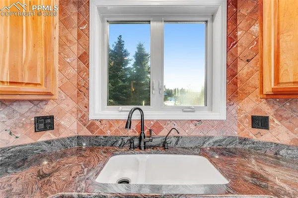 a bathroom with a granite countertop sink and a large mirror