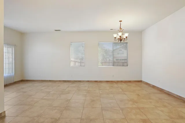 an empty room with chandelier fan