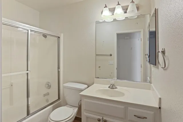 a bathroom with a sink vanity mirror and toilet