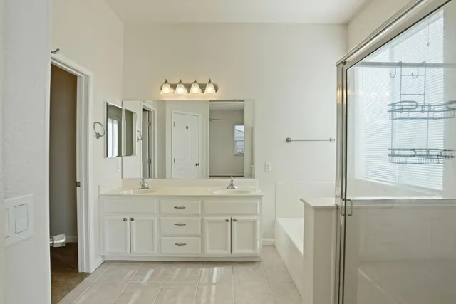 a bathroom with a double vanity sink and a mirror