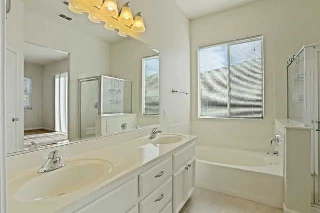 a bathroom with a tub a sink and a mirror