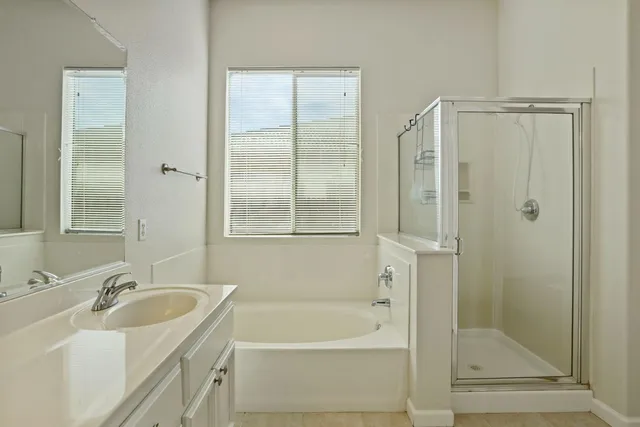 a bathroom with a tub sink and mirror