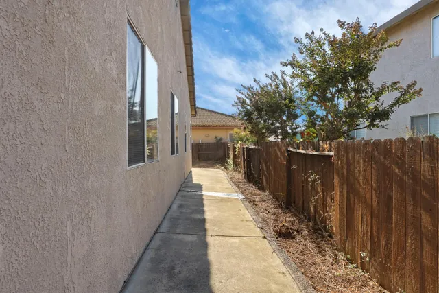 a view of a pathway of a house with wooden fence