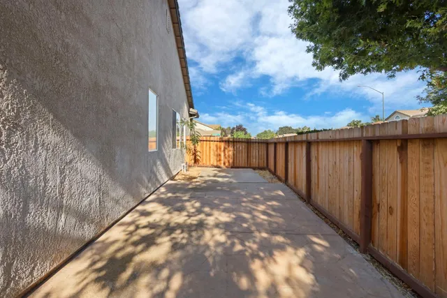 a view of a backyard with wooden fence