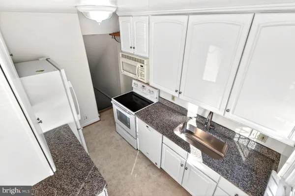 a kitchen with stainless steel appliances granite countertop a sink and a granite counter tops