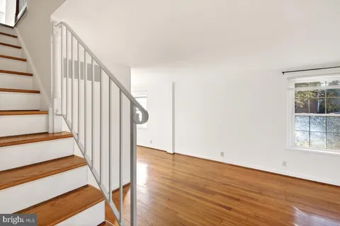 a view of staircase with wooden floor and white walls