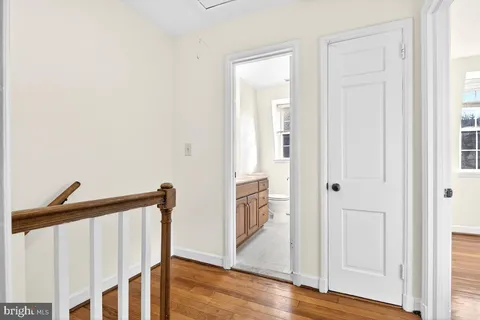 a view of a hallway with wooden floor and stairs