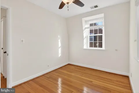 an empty room with a window and wooden floor