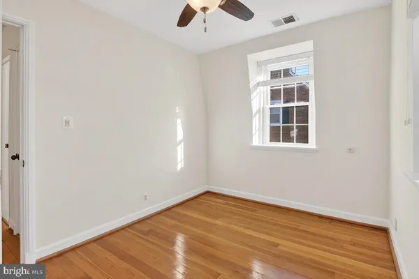 an empty room with a window and wooden floor