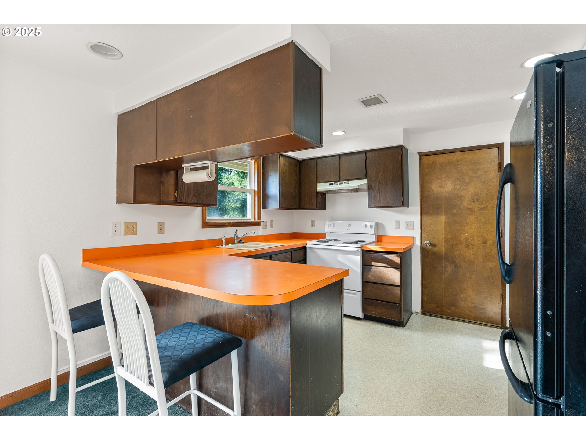 1521 Ranch Road Reedsport, OR 97467 - Photo 11 of 44 a kitchen with a table chairs refrigerator and a sink
