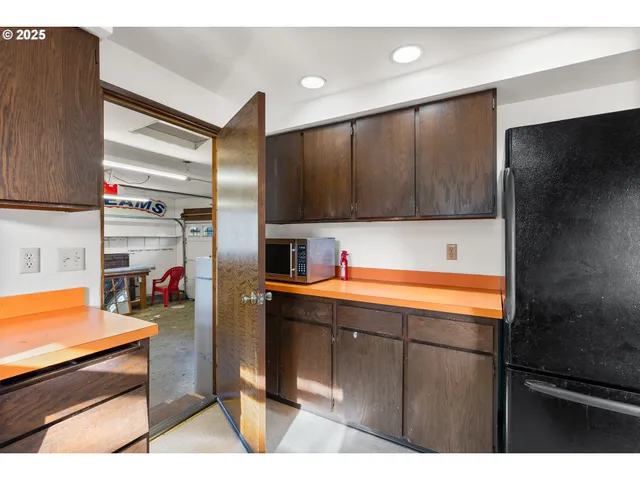 a kitchen with stainless steel appliances kitchen island granite countertop a refrigerator and a stove top oven