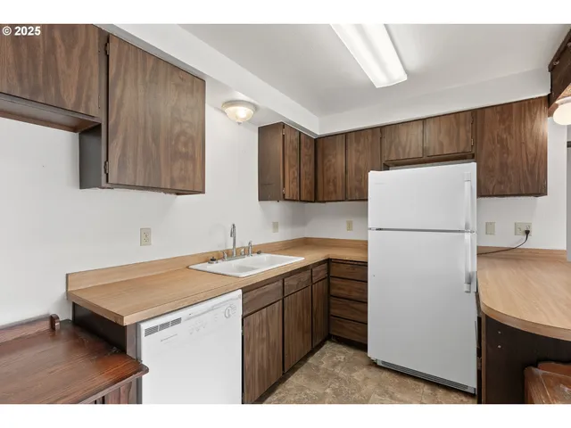 a open kitchen with stainless steel appliances kitchen island a refrigerator sink and cabinets