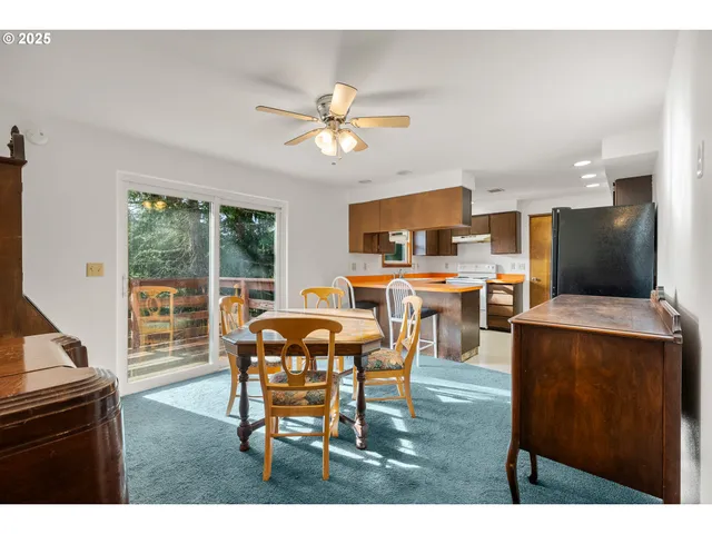 a dining room with furniture and a large window