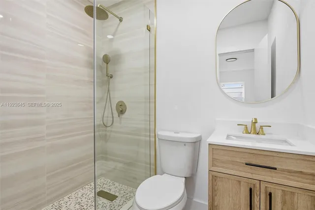 a bathroom with a toilet sink vanity and shower