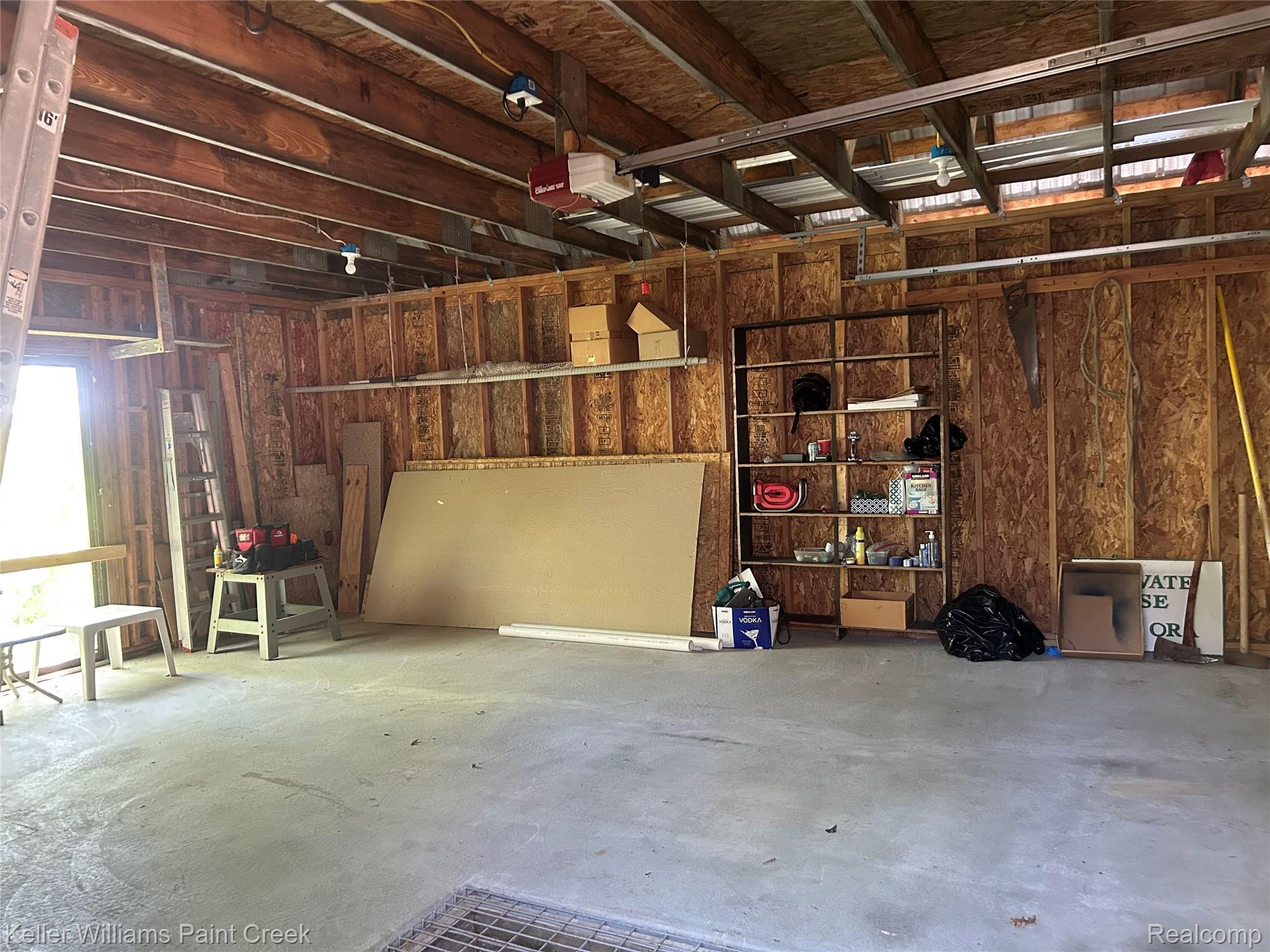 227 Ora Road Oxford, MI 48371 - Photo 55 of 60 Spacious garage interior featuring exposed wood framing, concrete flooring, and overhead lighting