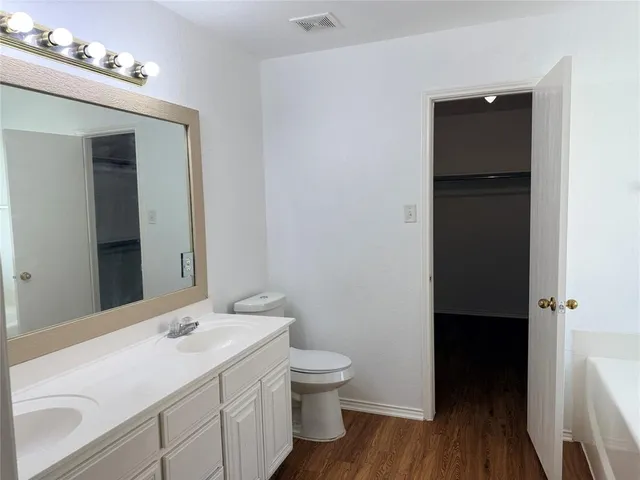 a bathroom with a sink a toilet and mirrors