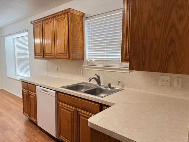 a kitchen with a sink cabinets and a window
