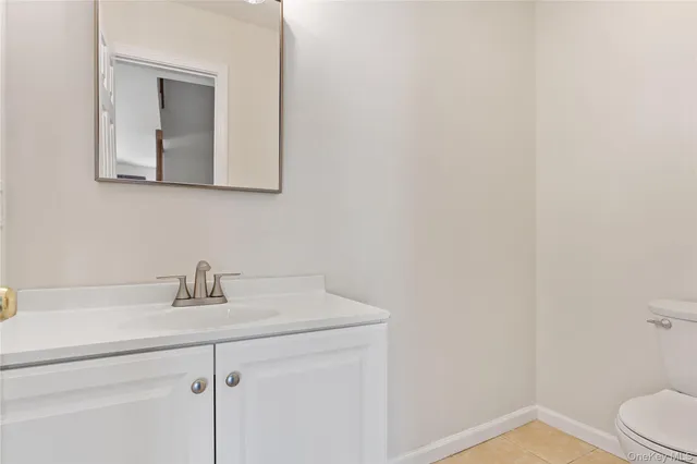 a bathroom with a toilet sink vanity and mirror