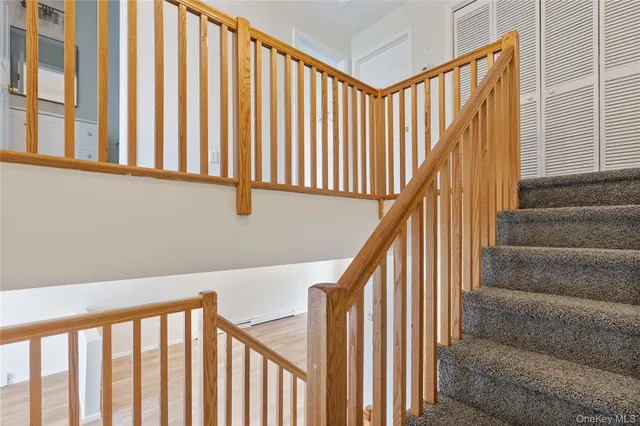 a view of staircase with railing and white walls