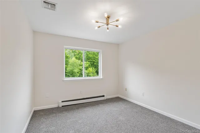 an empty room with a window and a fan