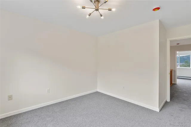 an empty room with a ceiling fan and carpet