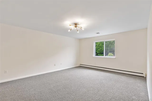 an empty room with a window and a ceiling fan