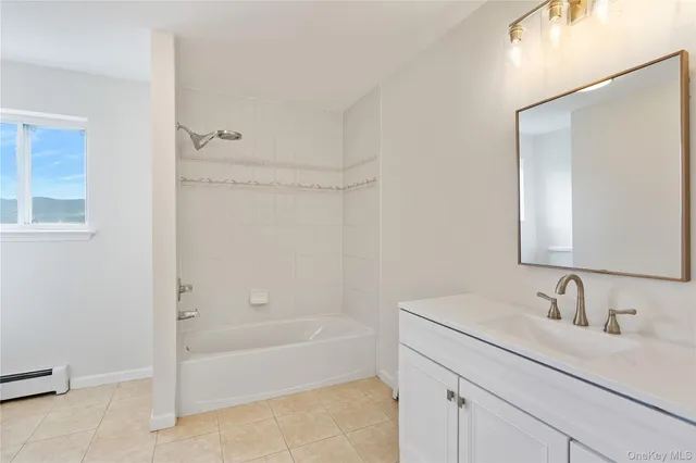 a bathroom with a granite countertop sink a mirror and a bathtub