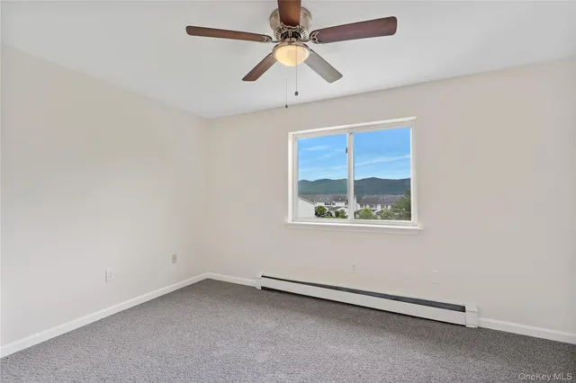 an empty room with a window and a fan