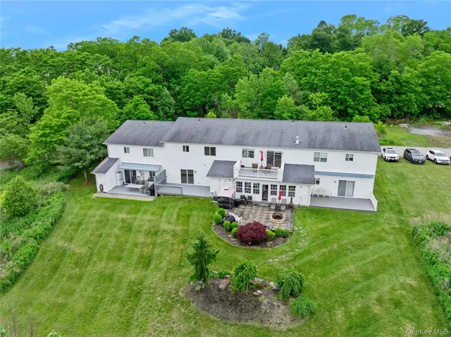 an aerial view of residential house with outdoor space and trees all around
