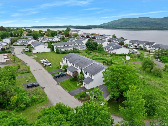 an aerial view of a city with lots of residential buildings ocean and mountain view in back