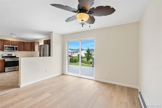 a view of a kitchen with wooden floor and a ceiling fan