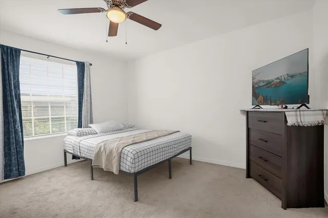 a bedroom with a bed and a flat tv screen on dresser