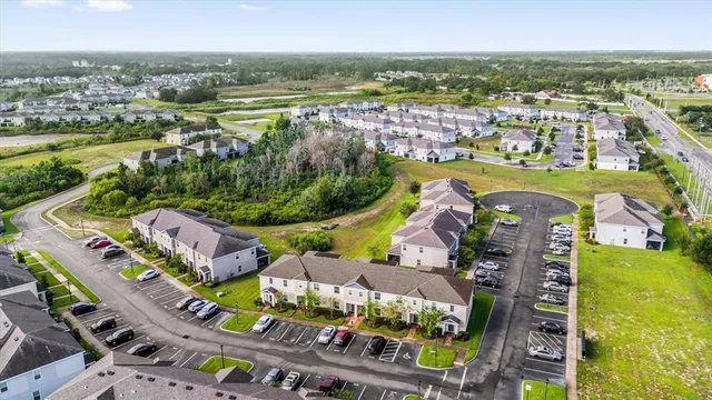 an aerial view of a city with lots of residential buildings ocean and mountain view in back