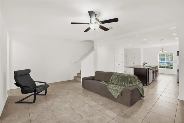 a living room with furniture and a ceiling fan