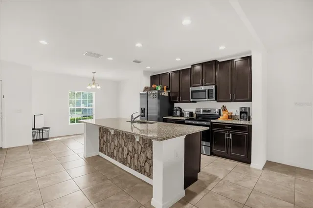a large kitchen with stainless steel appliances granite countertop a stove and a sink