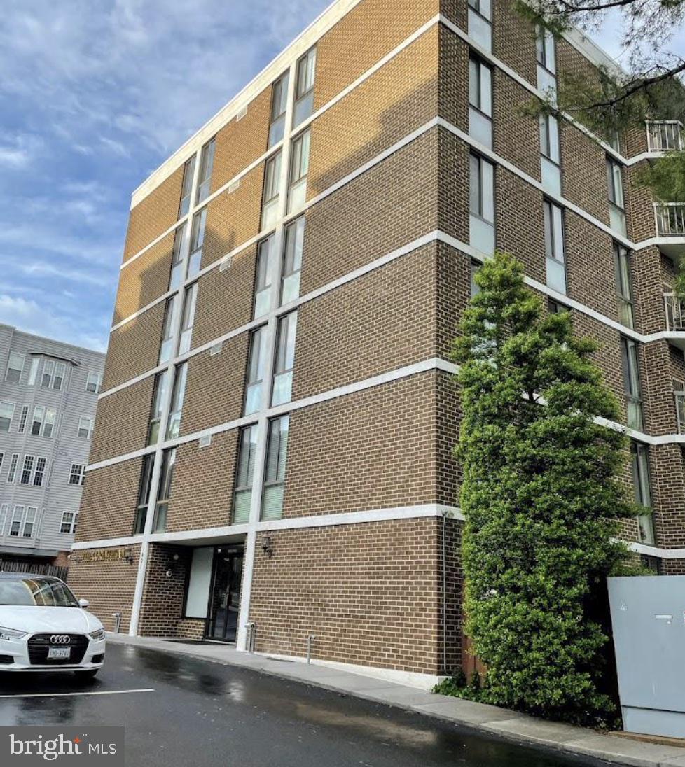 1401 North Rhodes Street, Unit 406 Arlington, VA 22209 - Photo 12 of 14 Modern brick facade with lush greenery.