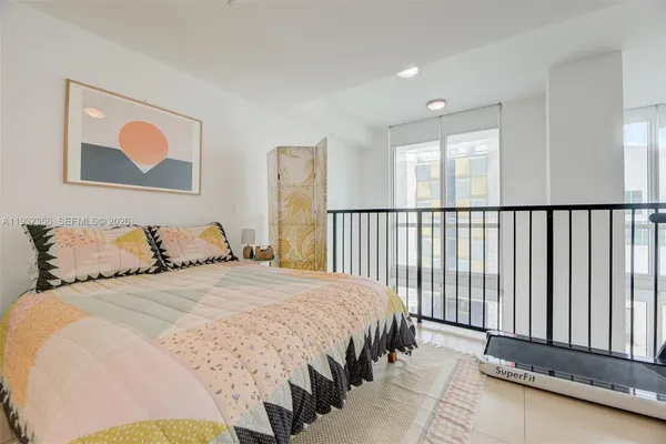 a bedroom with a bed and a large window