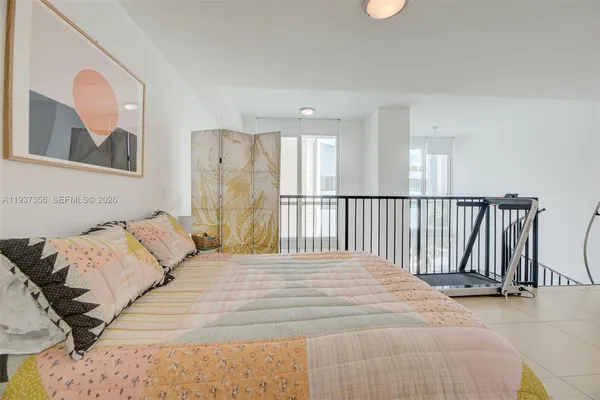 a bedroom with a large bed and a painting on the wall